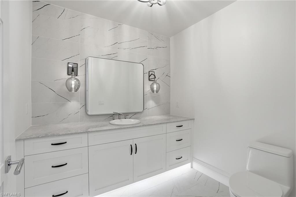 Bathroom with vanity and light marble finish flooring