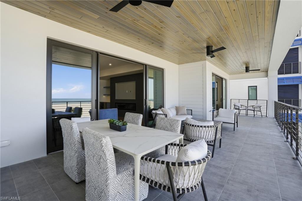 View of patio / terrace featuring ceiling fan, an outdoor living / dining area, and a water view