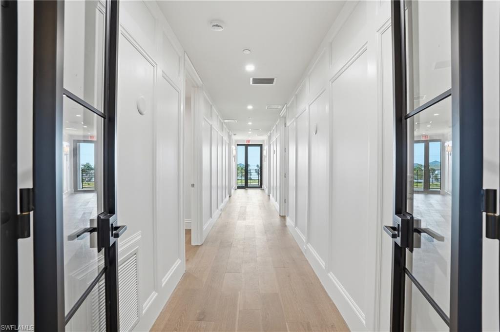 Corridor featuring light wood-type flooring and recessed lighting