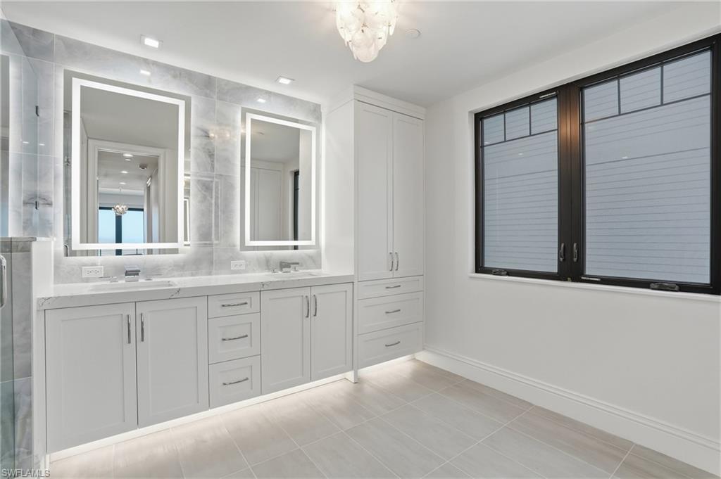 Full bath featuring double vanity and a shower stall