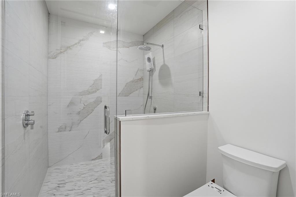 Bathroom with a shower stall and toilet