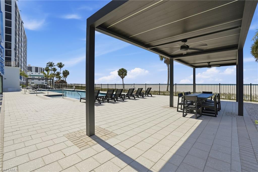 View of patio featuring a ceiling fan, a community pool, and outdoor dining area