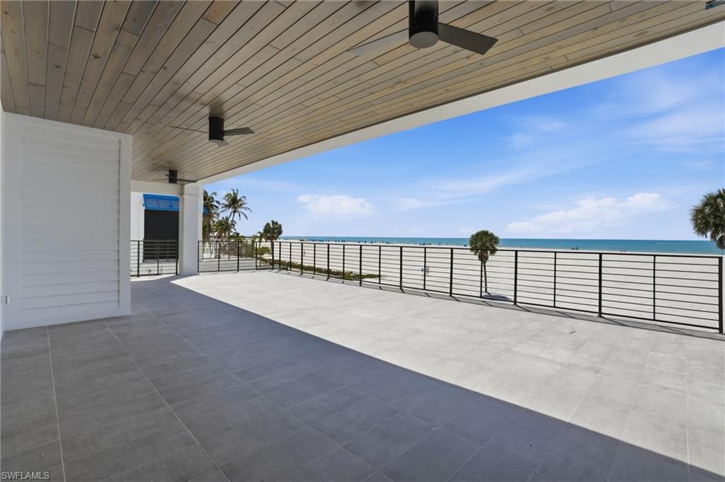 View of patio / terrace with ceiling fan and a water view