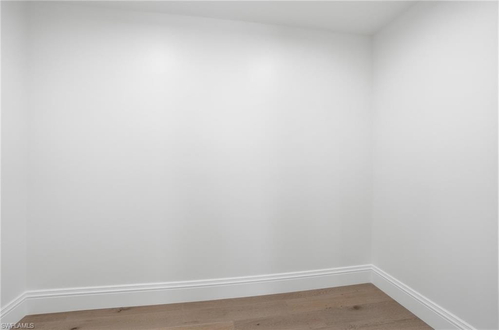 Spare room with baseboards and light wood-type flooring