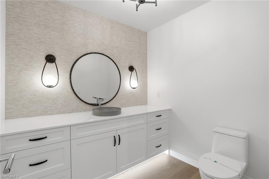 Half bathroom featuring vanity and light wood-type flooring
