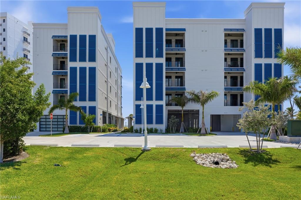 Contemporary multi-story building featuring white siding and blue accents - Virtually Edited Image