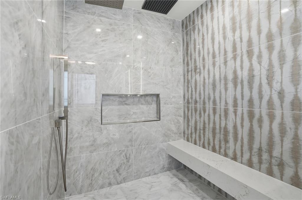 Full bath featuring a marble finish shower and marble finish floors