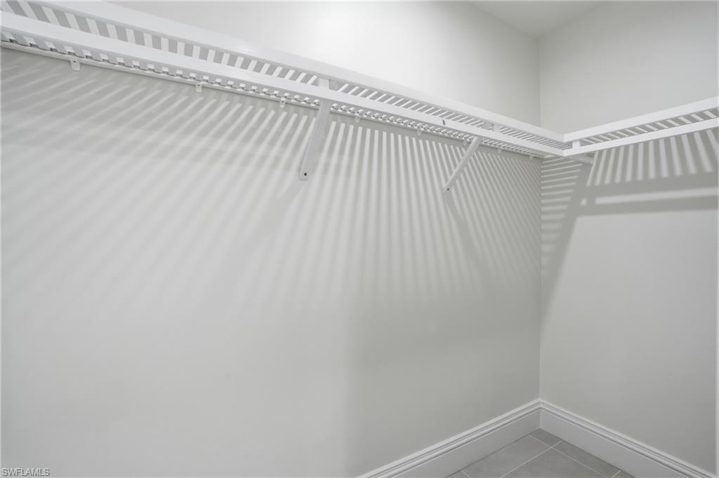 Walk in closet with light tile patterned floors