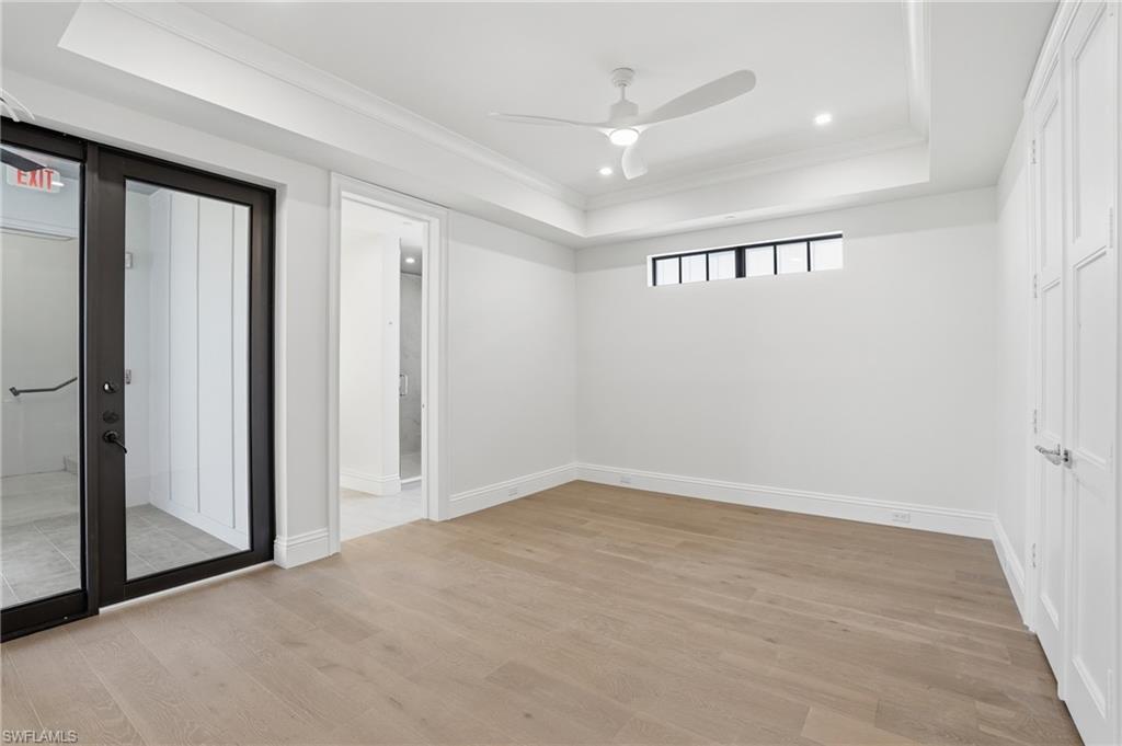 Spare room with ornamental molding, a raised ceiling, a ceiling fan, light wood-style floors, and recessed lighting