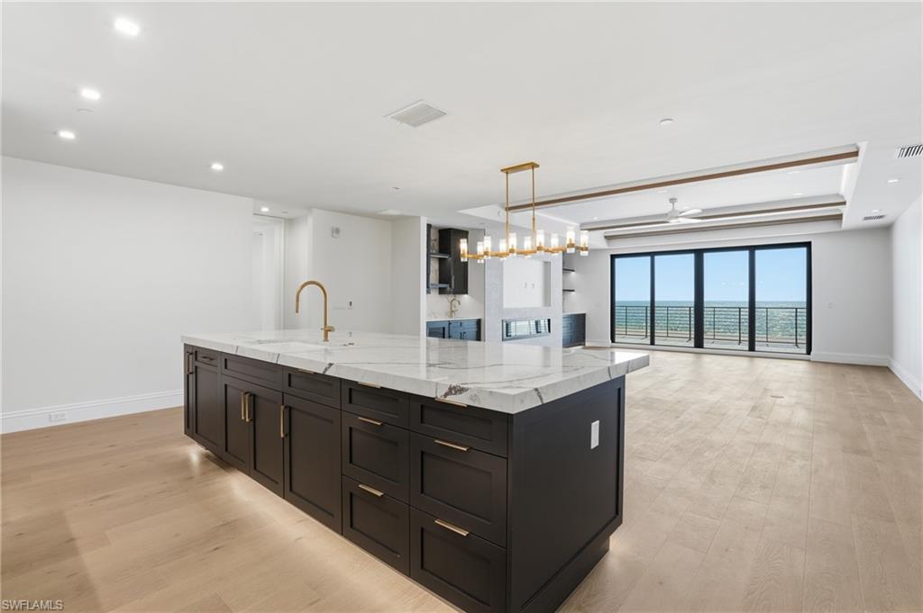 Kitchen with a center island with sink, open floor plan, light wood-type flooring, and ceiling fan