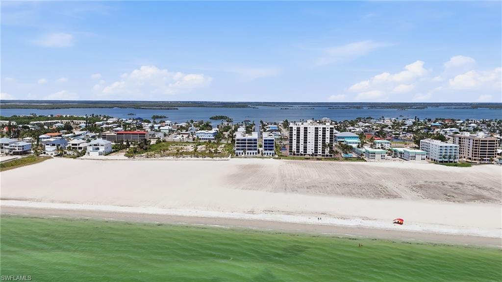 Coastal setting featuring a broad sandy beach and calm green waters - Virtually Edited Image