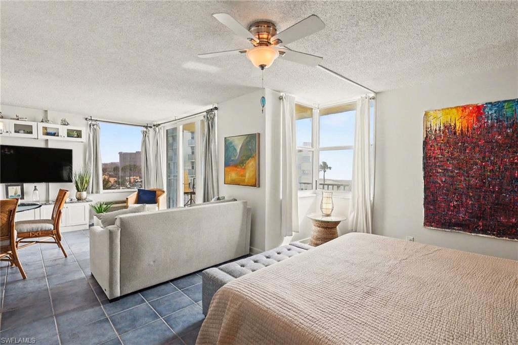 Bedroom with a textured ceiling, a ceiling fan, and tile patterned floors