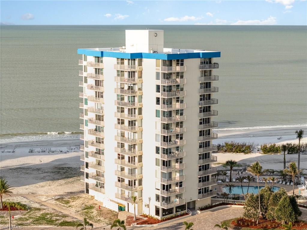 View of apartment building / complex with view of water and beach