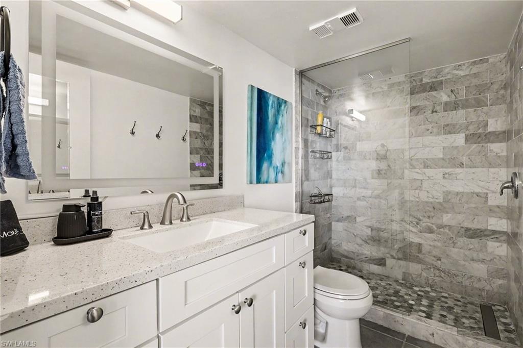 Bathroom with vanity and tiled shower