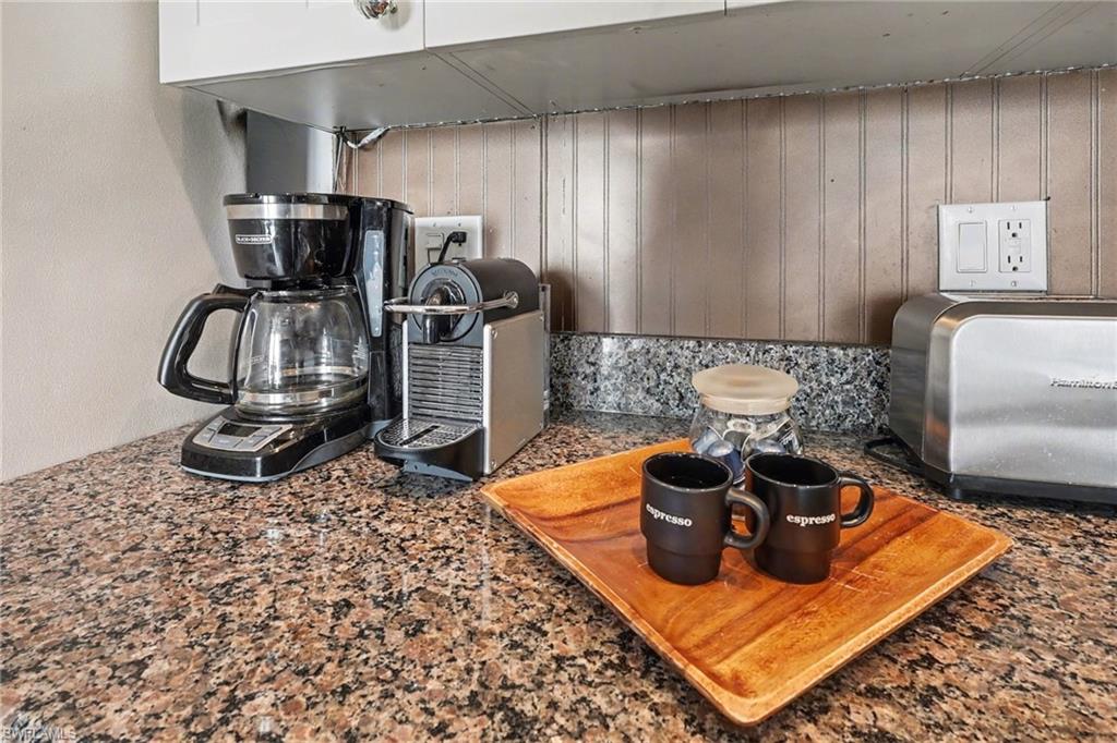 Kitchen view of dark stone countertops and wood walls