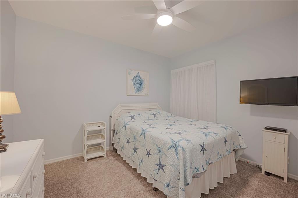 Bedroom with a ceiling fan and light colored carpet
