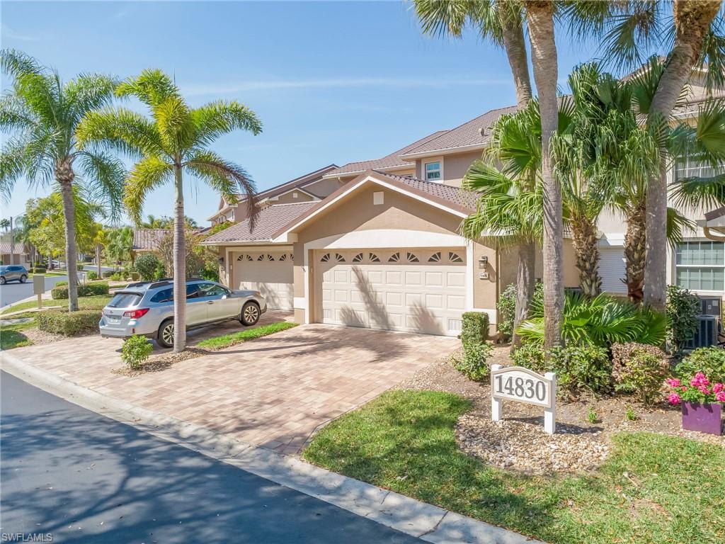 View of front of property featuring decorative driveway, stucco siding, a garage, and a tiled roof