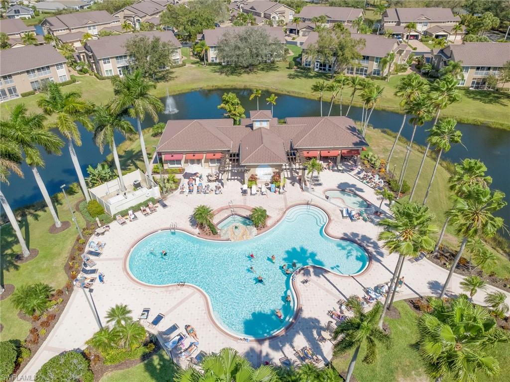 Community pool featuring a water view, a patio area, and a hot tub
