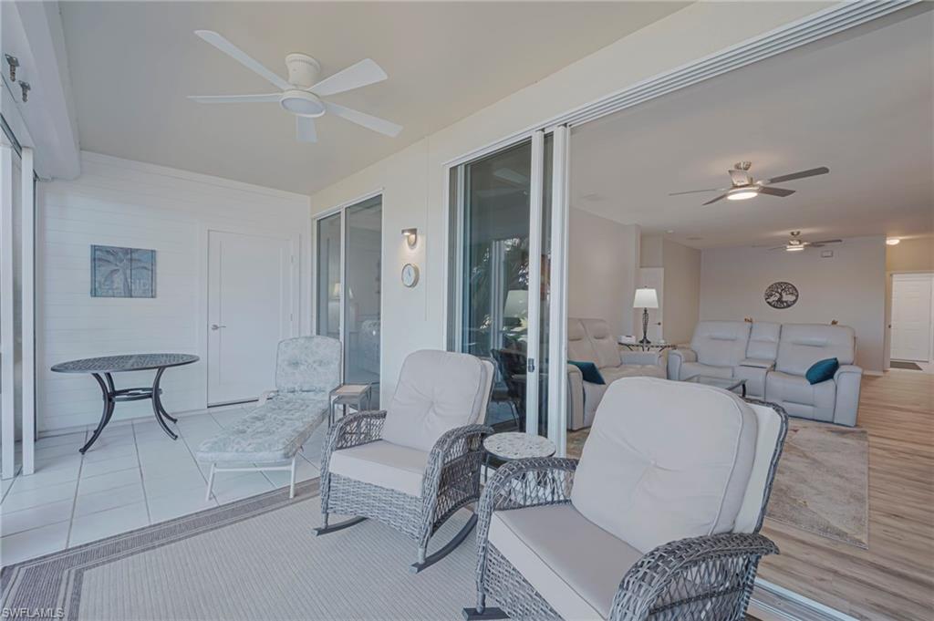 Sunroom / solarium featuring a ceiling fan, an outdoor living space, and a patio area