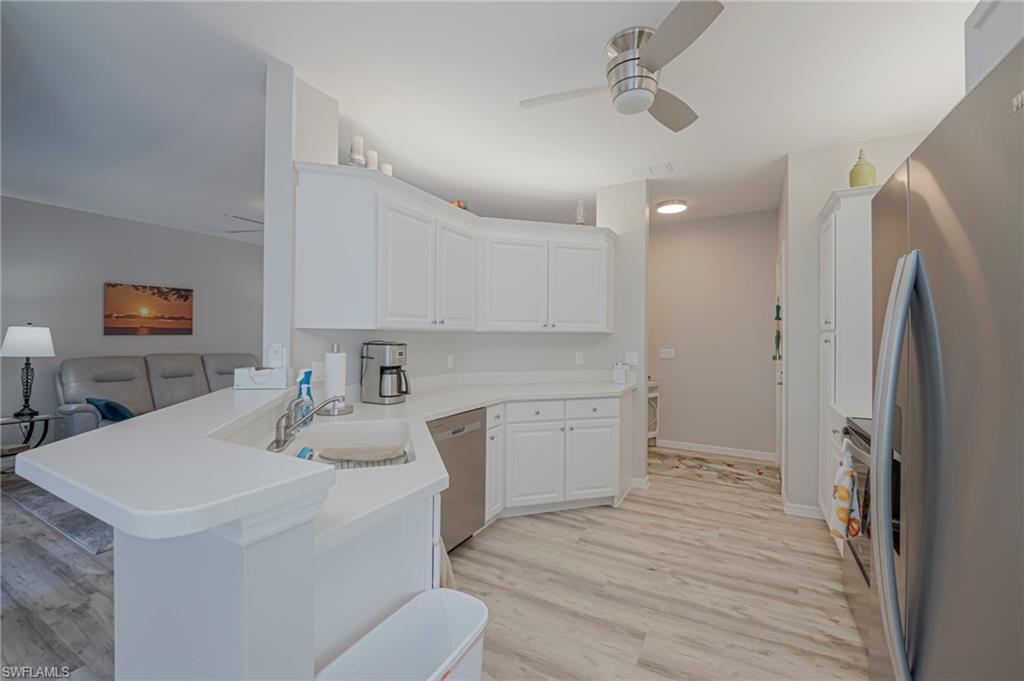 Kitchen featuring ceiling fan, stainless steel appliances, and white cabinets