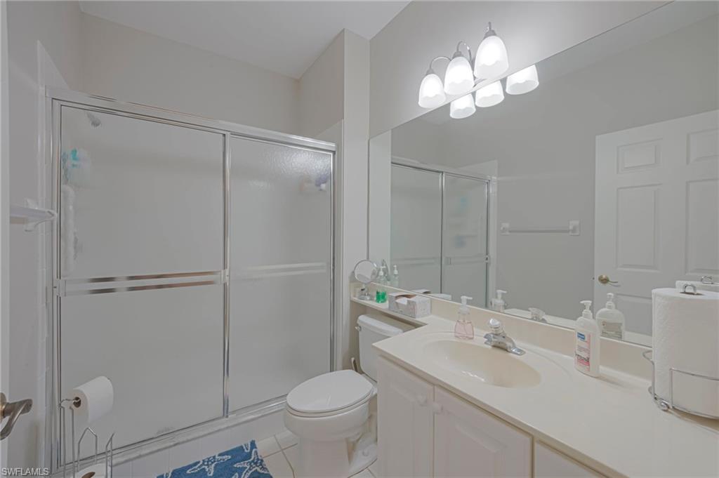 Bathroom with vanity, a shower stall, and light tile patterned floors