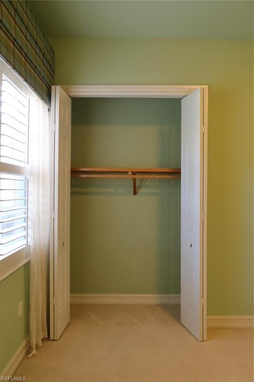 Bifold closet doors revealing an interior storage rod and shelving