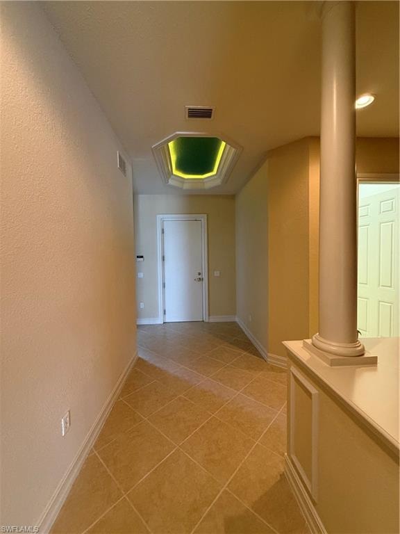 Hall featuring light tile patterned flooring and a textured wall
