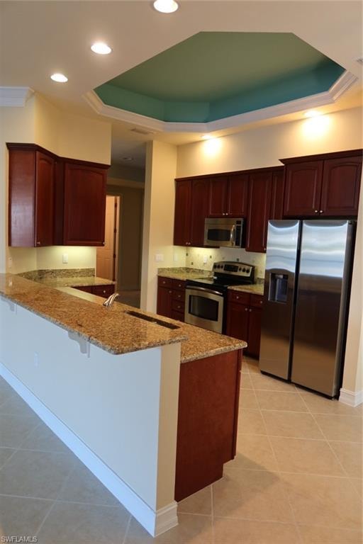 Kitchen featuring warm wood cabinetry, granite countertops, and stainless steel appliances