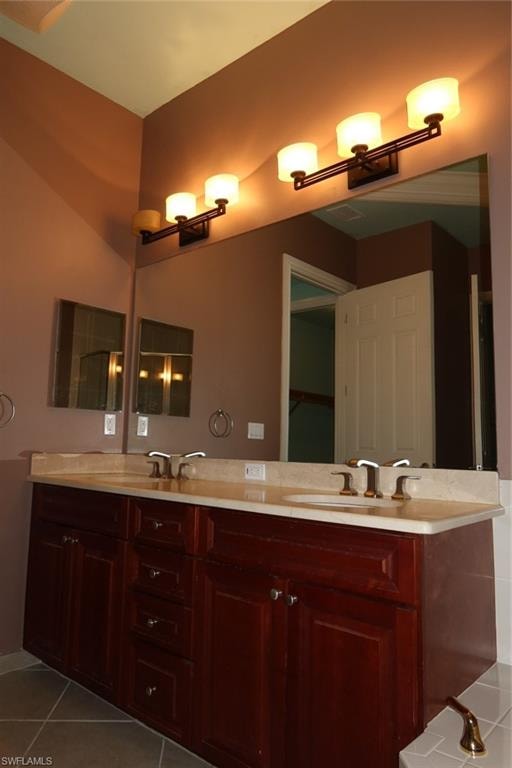 Dual vanity with rich wood cabinetry and a light-toned countertop, featuring two integrated sinks and brushed nickel faucets