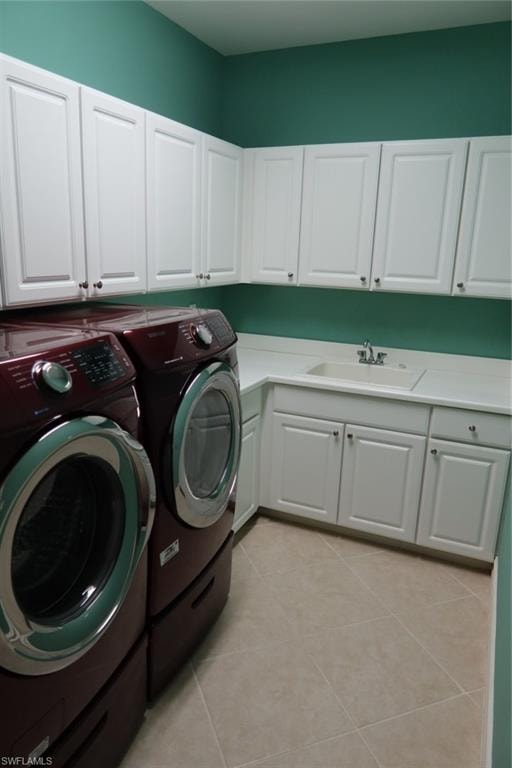 Dedicated laundry area featuring white shaker-style cabinetry, a built-in utility sink, light-toned countertop, and neutral-toned tile flooring