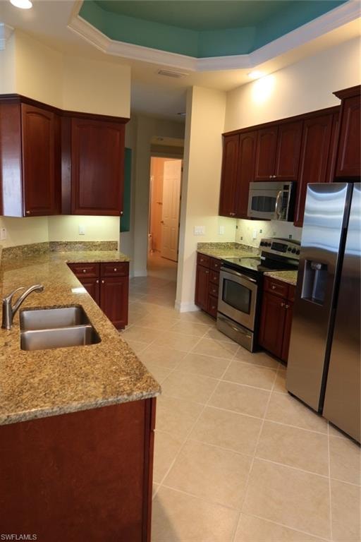 Kitchen featuring wood-finish cabinetry, stone countertops, and a stainless steel appliance suite