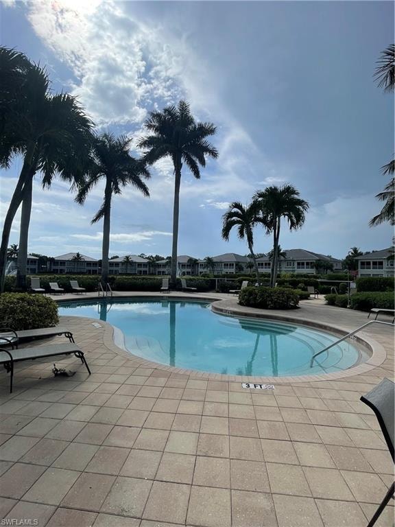 Community pool with a patio and a residential view