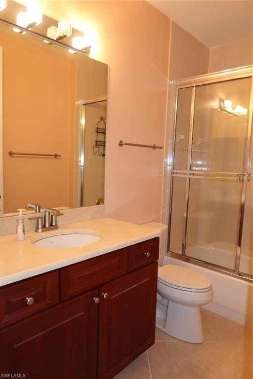 Bathroom featuring a wood-finish vanity with a light-toned countertop, an undermount sink, and a brushed nickel faucet