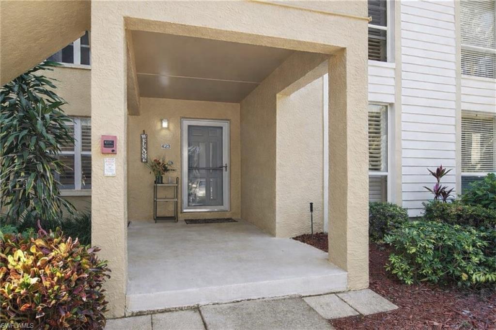 View of exterior entry featuring stucco siding and a porch