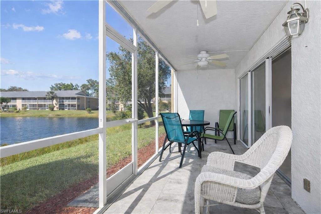 Sunroom featuring a ceiling fan, outdoor dining space, and a water view