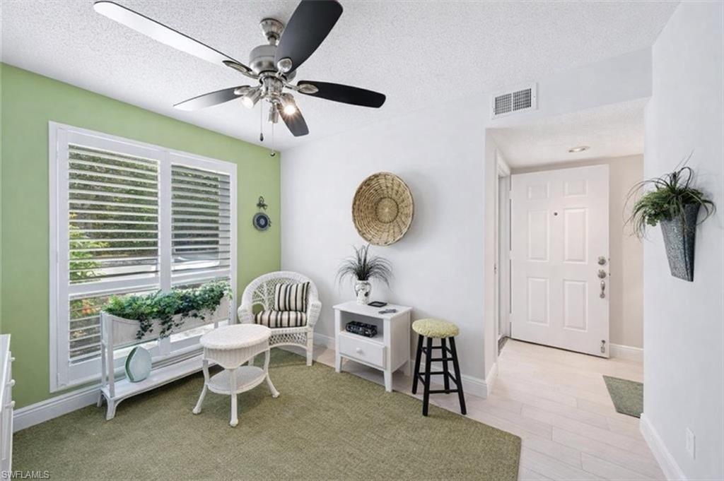 Sitting room featuring a textured ceiling, ceiling fan, and light wood-style flooring