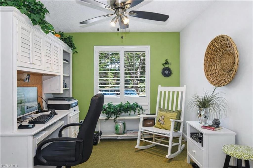 Home office with a ceiling fan and dark carpet