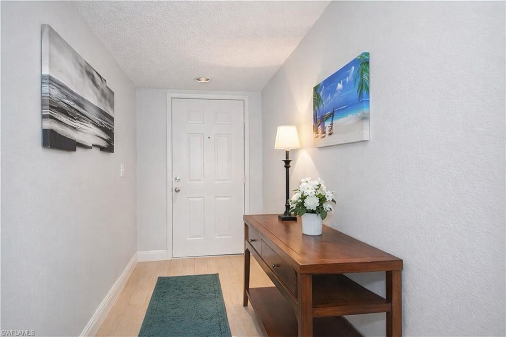Doorway to outside with wood finished floors and a textured ceiling