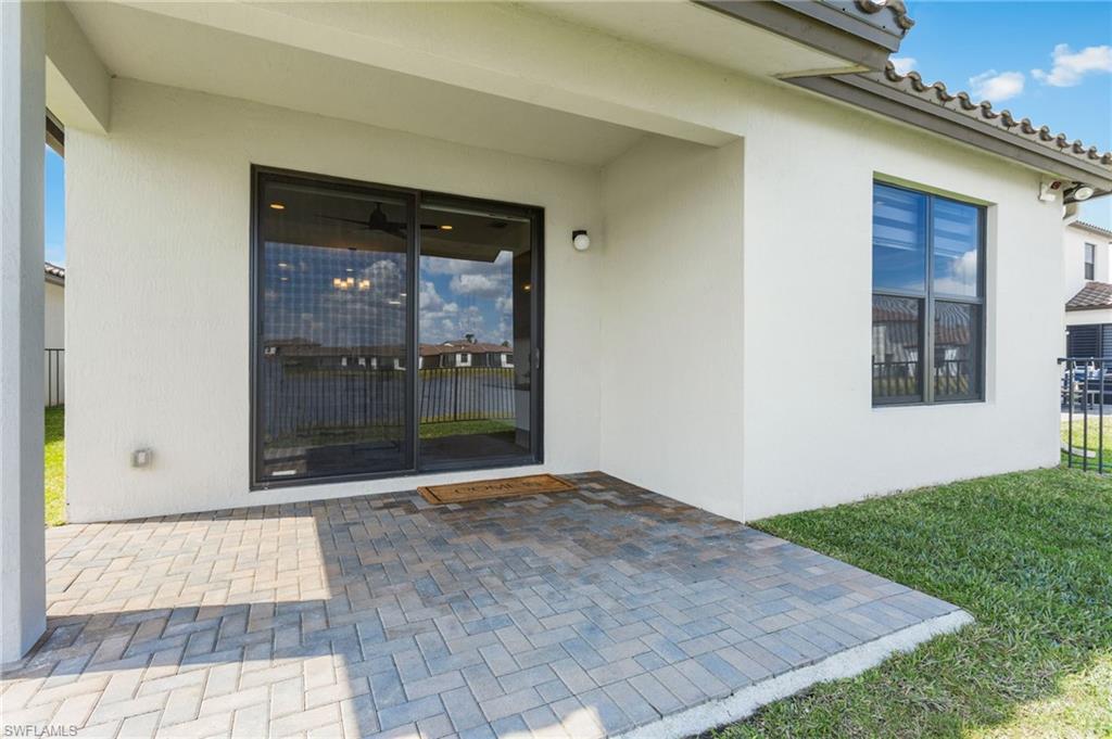 Property entrance with a patio area and stucco siding