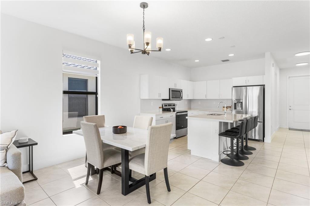 Dining room with light tile patterned floors and a chandelier