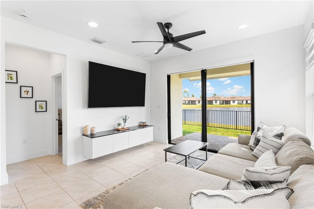 Living area with ceiling fan, light tile patterned floors, and recessed lighting
