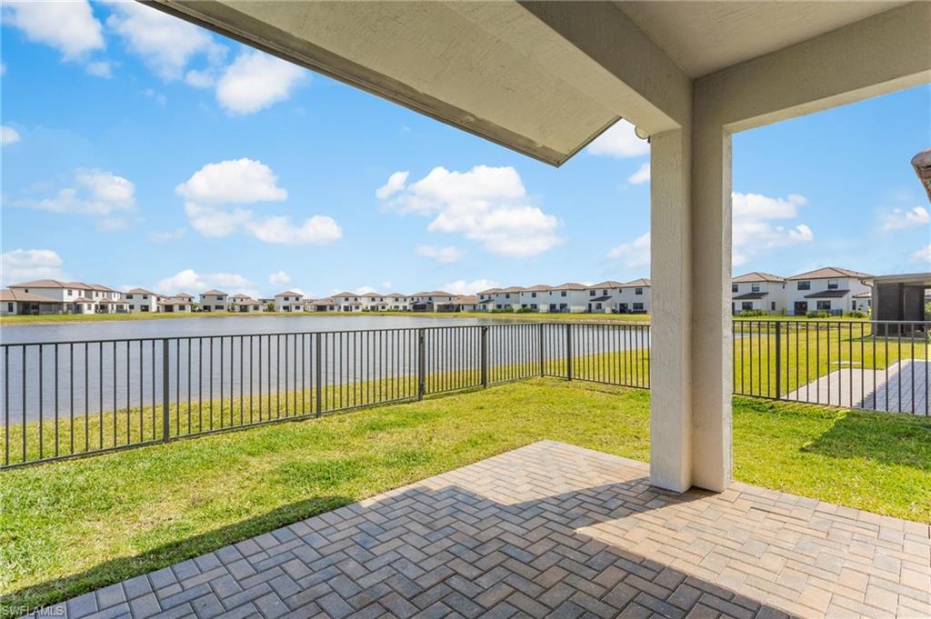 Fenced backyard with a patio area, a residential view, and a water view