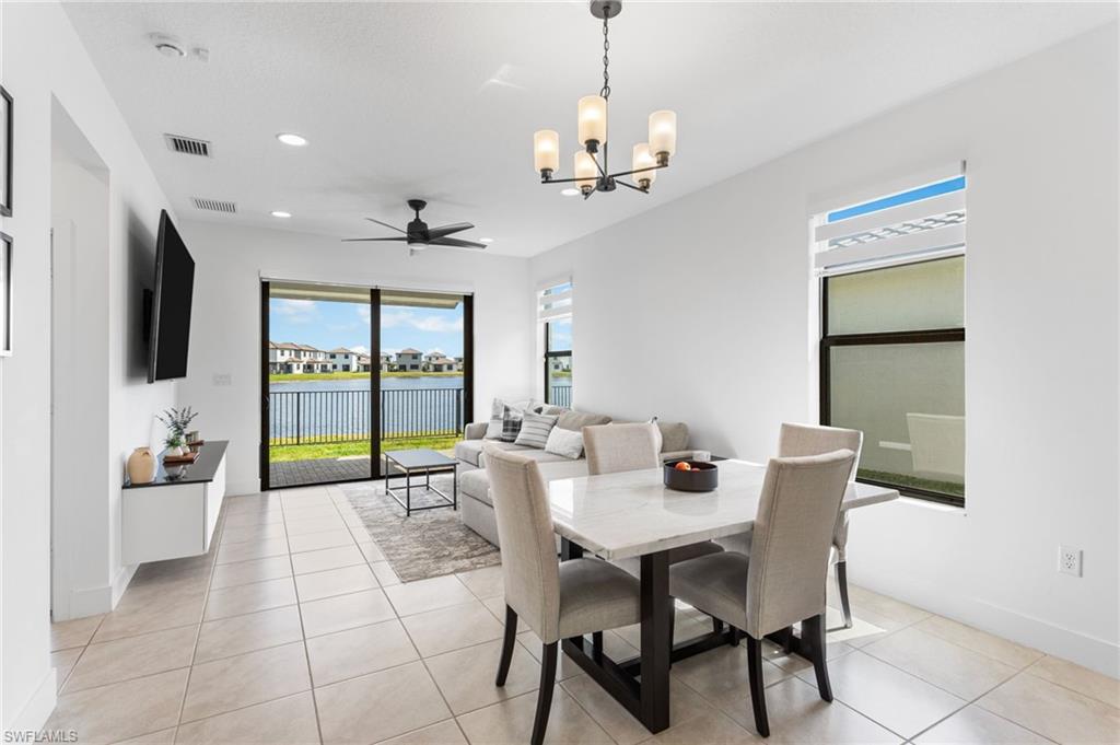 Dining space featuring hanging lights, a ceiling fan, and light tile patterned floors