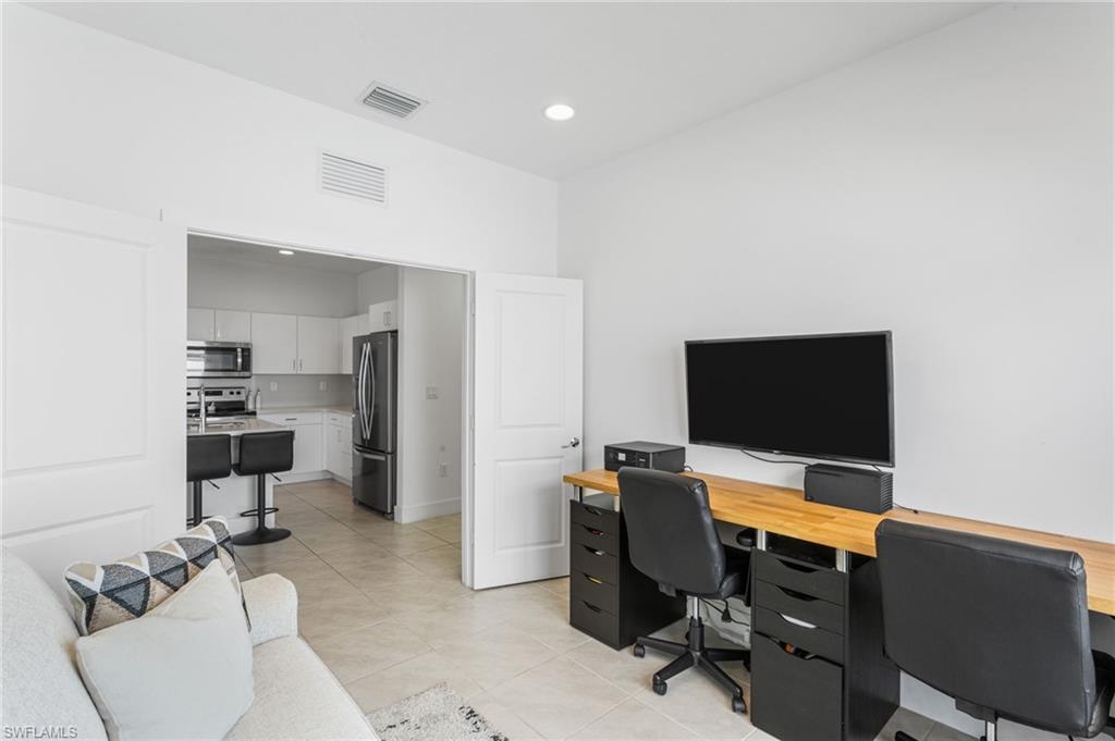 Home office with light tile patterned floors and recessed lighting