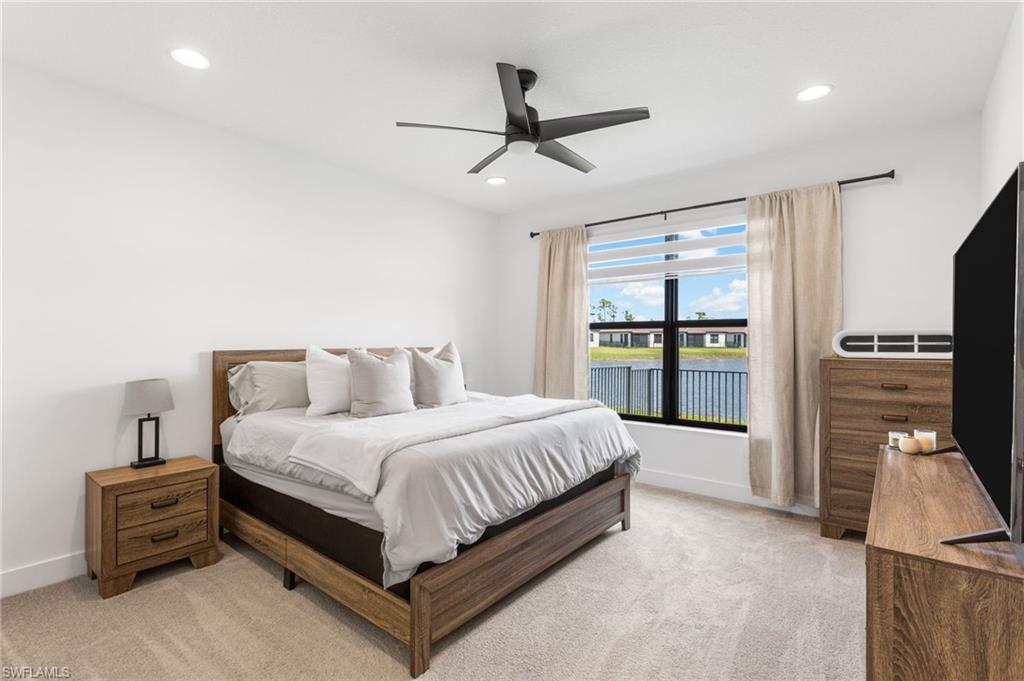 Bedroom with light carpet, ceiling fan, and recessed lighting