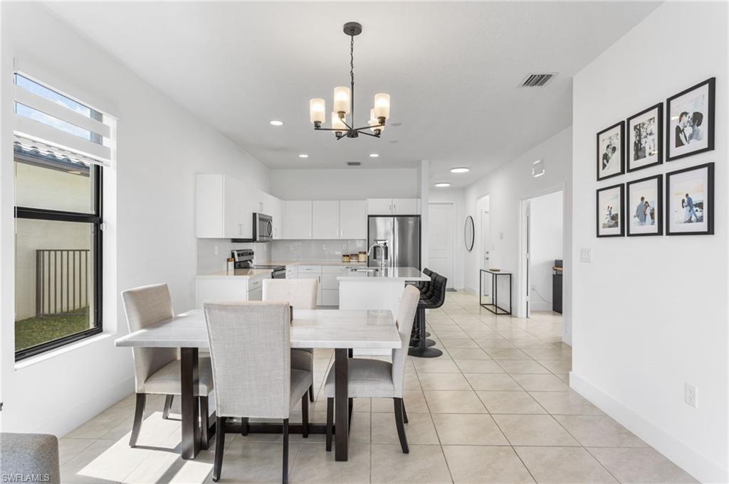 Dining space featuring hanging lights and light tile patterned floors