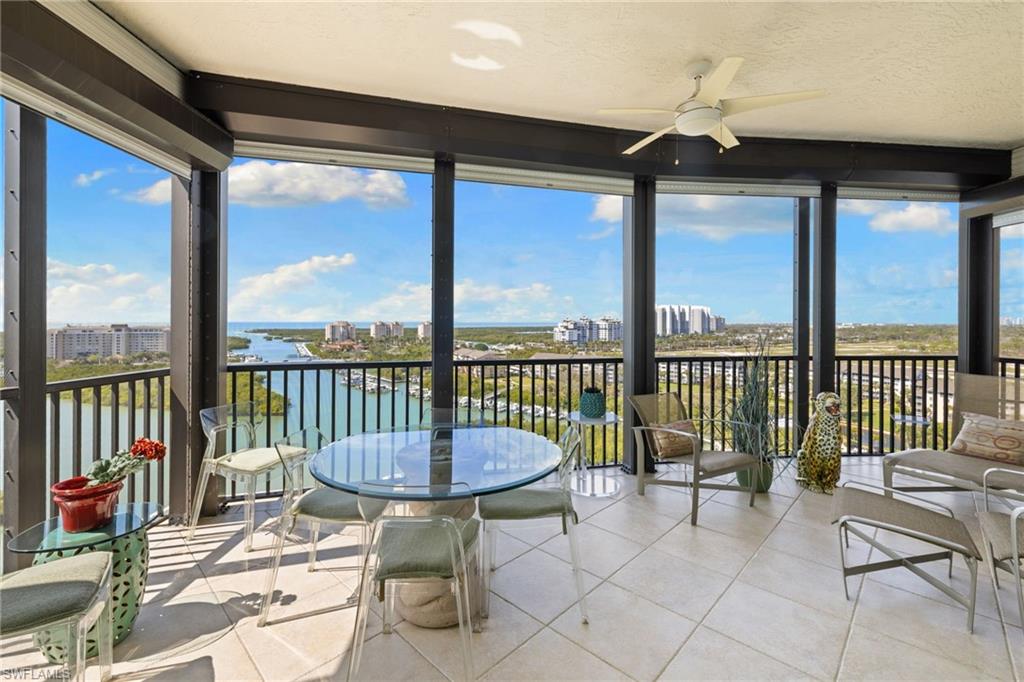 Sunroom / solarium with a city view, expansive windows, a textured ceiling, a water view, and plenty of natural light