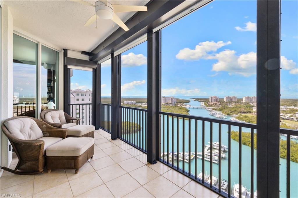 Sunroom featuring a water view, floor to ceiling windows, a view of city, tile patterned flooring, and a textured ceiling