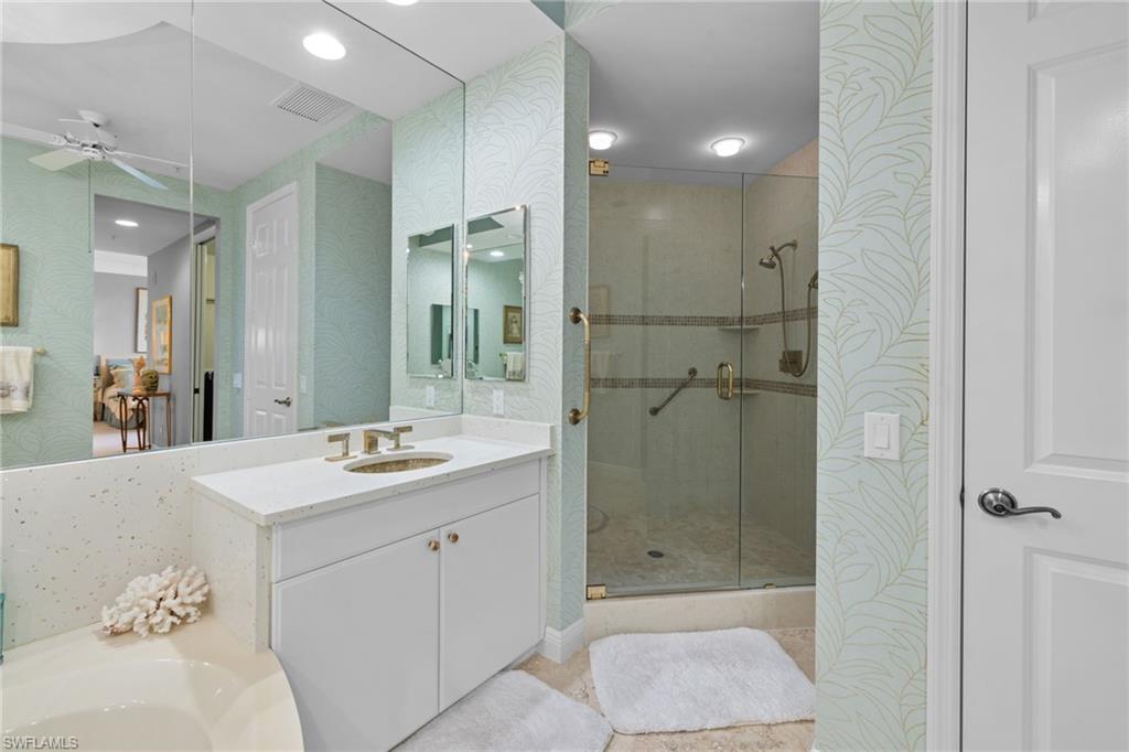 Bathroom with wallpapered walls, a stall shower, vanity, a ceiling fan, and recessed lighting