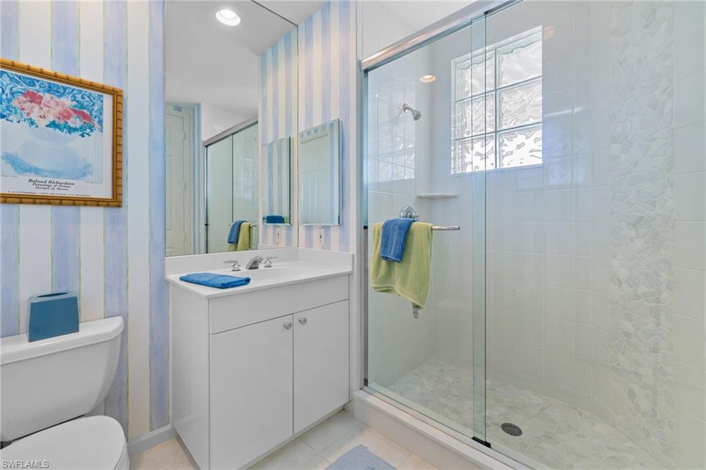 Full bathroom featuring wallpapered walls, vanity, a stall shower, light tile patterned floors, and recessed lighting